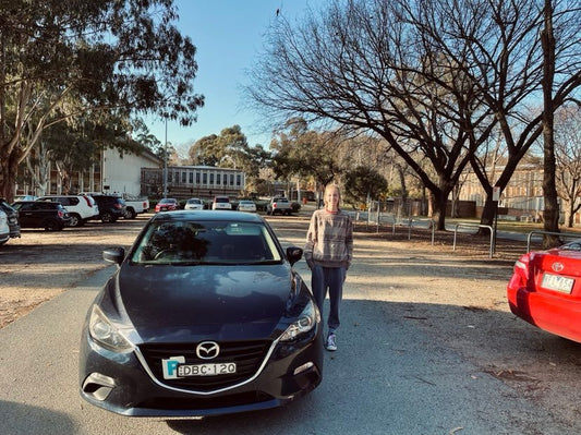 lady pictured standing on the right side of her car