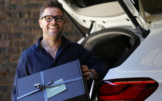 man with glasses on smiling holding an autonomy gift box