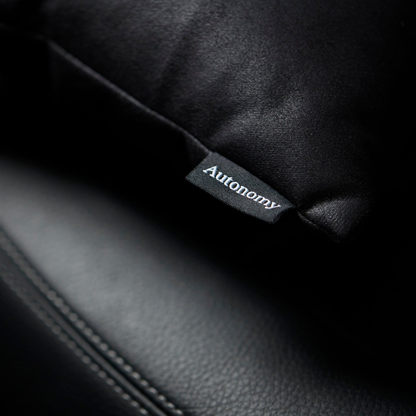 autonomy logo zoom in pictured from the travel pillow on a leather car seat