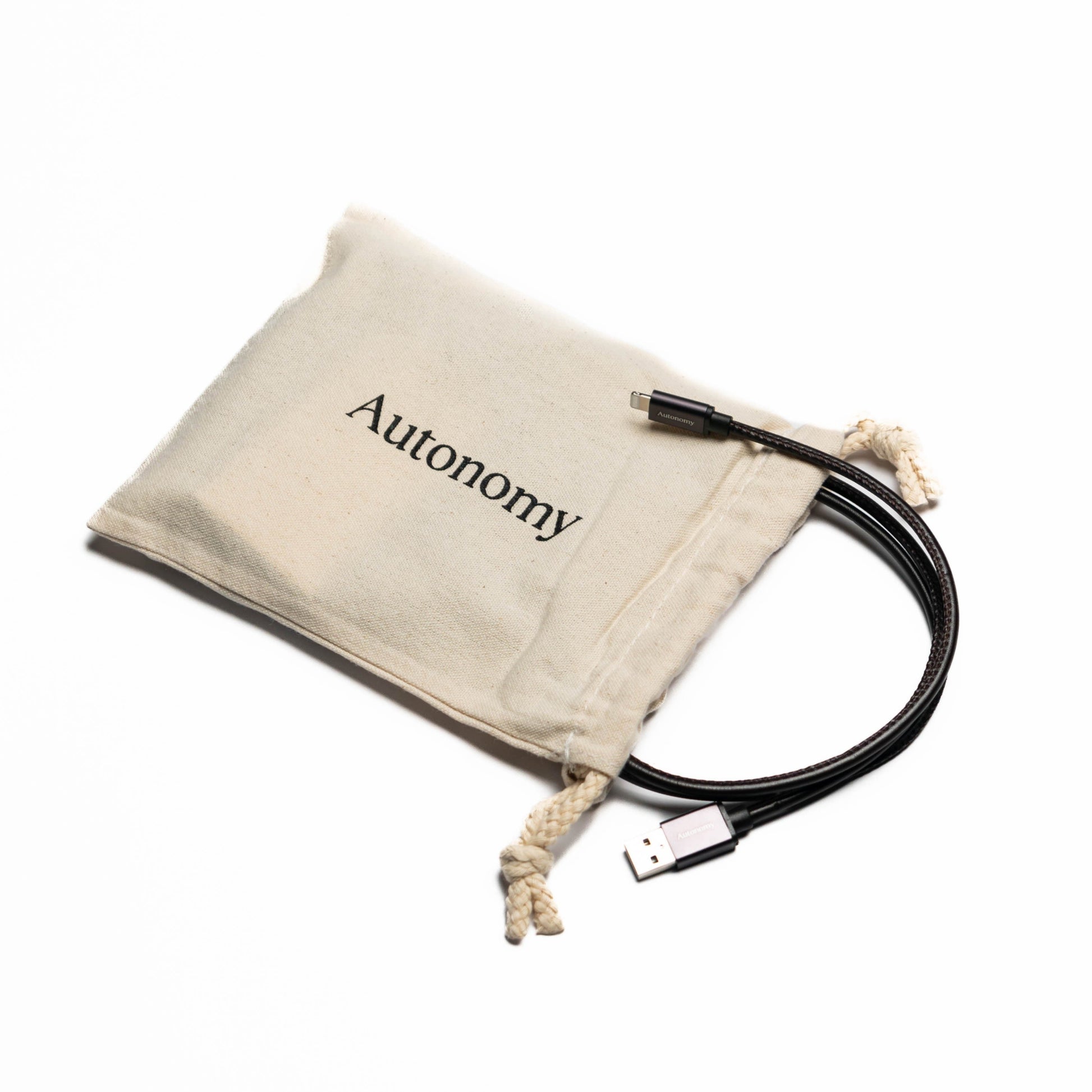Black autonomy branded usb iphone charger cable with its satchel that it comes in on a white background